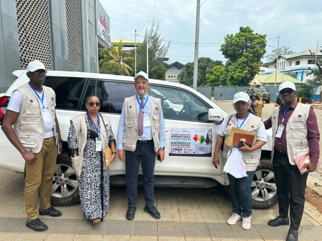 L'équipe de la mission d'observation de l'OIDT devant le véhicule de la mission, Conakry